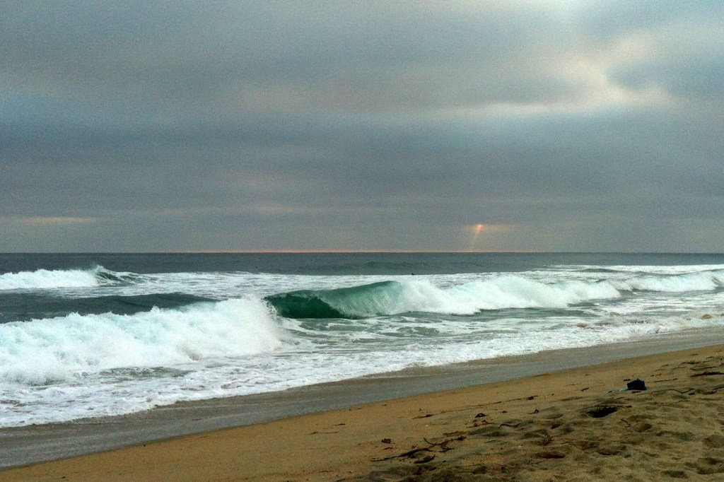 Green wave and distant beam of sunlight.